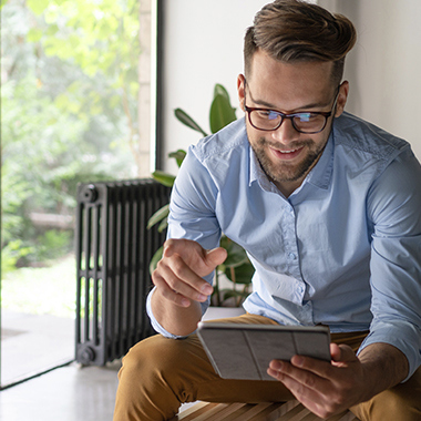 Man with ipad next to a window